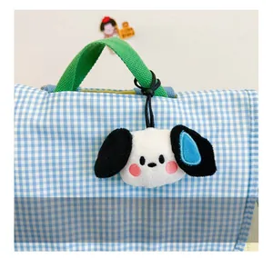 Close-up of a cute plush dog pendant on a blue checkered backpack for kids