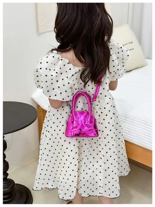 Sac bandoulière brillant en forme de coquille avec matelassage sur un mannequin enfant