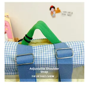 Detail of adjustable blue shoulder strap with silver buckle on a plaid backpack