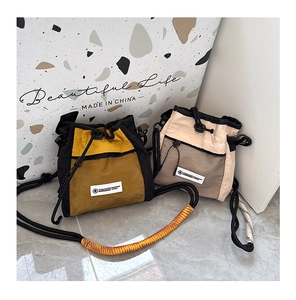 Detail of drawstring bucket bags featuring mesh pockets and woven rope shoulder straps