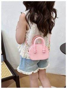Mini borsa a tracolla rosa per bambini con trama litchi mostrata su una modella