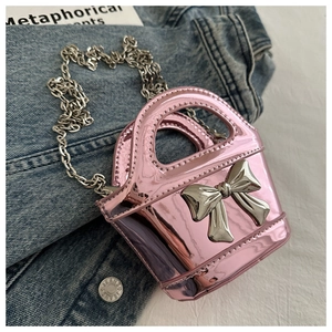 Detail of pink laser surface kids crossbody bag with large silver bow and chain strap