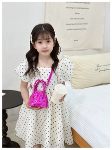 Détail d'un sac bandoulière rose fuchsia brillant avec motif matelassé pour filles