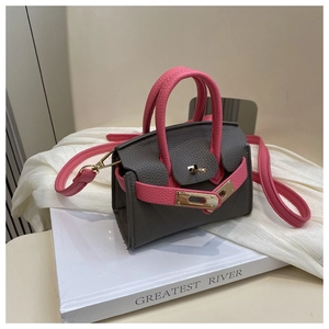 Detail view of mini two-tone shoulder bag with metal turn-lock and pink shoulder strap