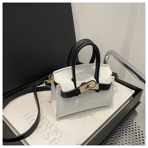 Detail of bicolored mini handbag showing white pebble leather and gold turn-lock closure