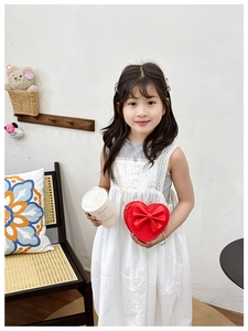 Détail du sac bandoulière rouge en forme de cœur pour fille avec nœud et chaîne dorée