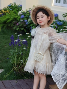 Robe d'été pour fille avec sac perlé et chapeau de paille dans un jardin fleuri