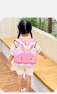 Pink rabbit-shaped backpack with long ears and bow detail on a child back in nature