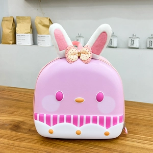 Detailed view of pink cartoon bunny backpack with plush ears and bow tie on hard shell