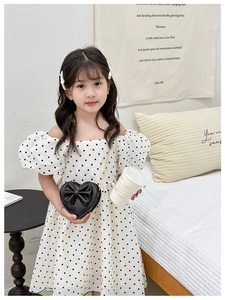 Robe à pois et sac bandoulière en forme de cœur avec nœud sur un mannequin enfant