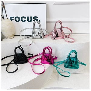 Détail de mini sacs à main matelassés aux couleurs métallisées sur escalier blanc