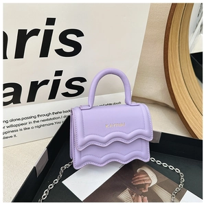 Detail of lavender purple mini handbag with wavy flap, gold logo, and silver chain strap