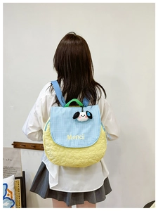Detail of colorful quilted backpack with heart pattern and cute dog plush pendant charm