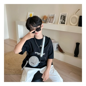 Detail of trendy silver round crossbody bag styled with a modern kids street style outfit