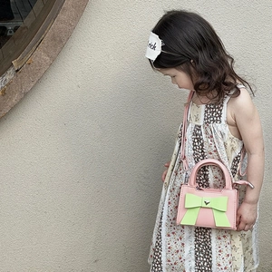 Vue détaillée du sac rose pour enfants avec nœud vert et boucle en cœur argenté