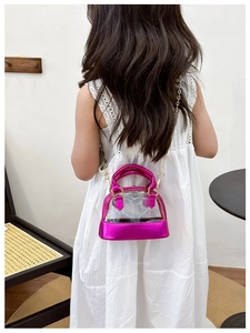 Toddler showing rose red shell shaped jelly crossbody bag with gold chain strap