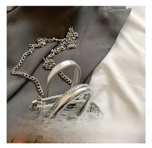 Close-up of shiny silver metallic mini bag with chain strap and reflective mirror finish