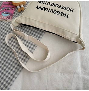 Détail du sac bandoulière en toile avec imprimé lettres contrastées et sangle réglable