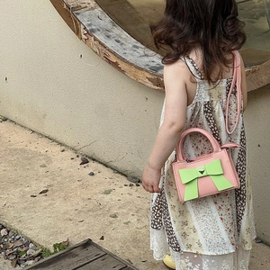 Sac bandoulière enfant en cuir rose avec nœud vert et boucle métallique en cœur