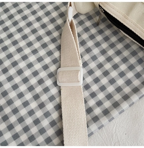 Détail de la bandoulière ajustable et de la fermeture éclair du sac en toile pour enfant