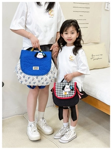 Detail of parent-child backpacks with cute puppy charms and floral or checkered patterns