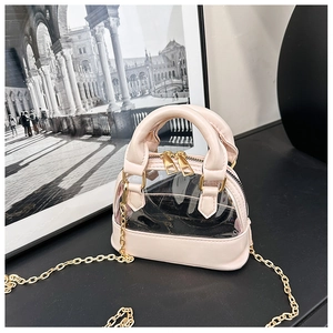 Detailed view of pink shell-shaped jelly bag with gold chain strap on black surface