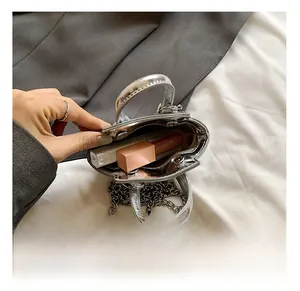Internal view of silver metallic mini bag showing capacity for lipsticks and chain strap