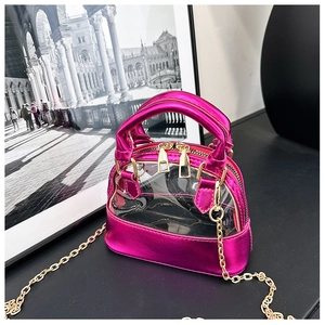 Detail of rose red metallic leather and transparent PVC shell-shaped crossbody bag