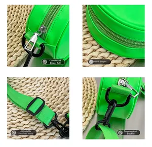 Detail view of neon green round bag showing metal puller, zipper and adjustable strap