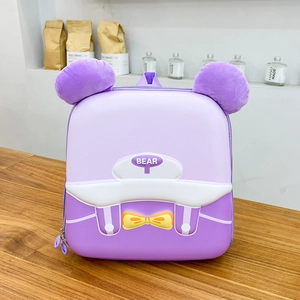 Dettaglio dello zaino a forma di orso viola con orecchie di peluche e fiocco giallo