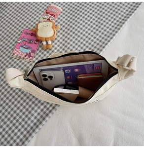 Détail de l'intérieur spacieux d'un sac bandoulière en toile avec tablette et objets
