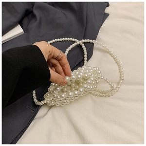 Detail view of handmade white pearl beaded mini bag with elegant woven shoulder strap