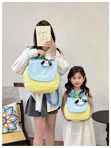 Detail of parent-child backpack set with yellow quilted fabric and cute dog charm