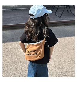 Vue arrière d'un enfant portant un sac bandoulière en toile ocre avec imprimé artistique