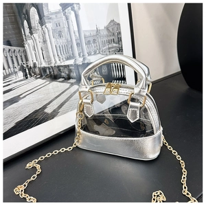 Detail of silver shell-shaped jelly bag with gold chain strap and clear PVC texture