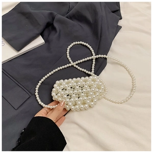 Detail view of mini white faux pearl woven crossbody bag for girls with long strap