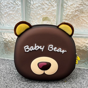 Detail of brown cartoon bear kids backpack with Baby Bear text and yellow dual zippers