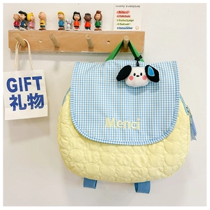 Close-up of yellow heart quilted children's backpack with blue plaid and puppy charm
