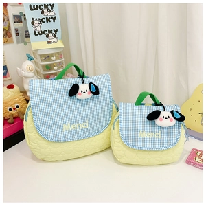 Close-up of quilted yellow backpacks with blue checkered flaps and cute puppy charms