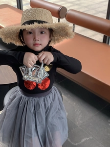 Asian child model showing silver metallic crossbody bag with black cherry top and grey skirt