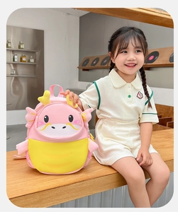Close-up of pink and yellow cartoon dragon backpack with 3D horns and cute embroidery