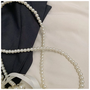 Détail de la bandoulière en perles blanches rondes pour sac à panier de fille