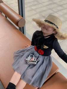 Fashionable child model in layered grey tutu skirt and shiny silver crossbody bag
