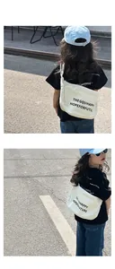 Détail d'un sac bandoulière blanc en toile pour enfant avec imprimé graphique urbain