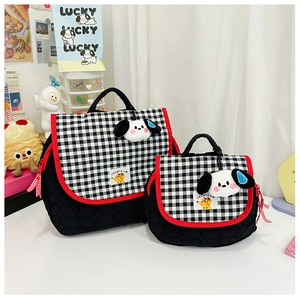 Macro shot of black quilted bag set with checkered flap and cute dog plush charm