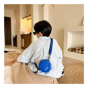 Detail of round blue crossbody bag for kids with Cool lettering and adjustable strap