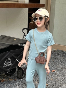 Gros plan mini sac bandoulière marron avec imprimé MOU & BAGS sur ensemble tricot enfant