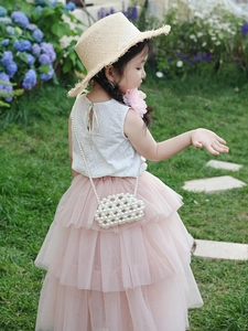 Detail of white lace sleeveless top with bow and layered pink tulle skirt for girls