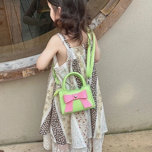 Sac à bandoulière vert pour enfants avec gros nœud rose et détail de cœur