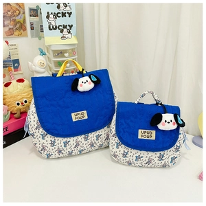 Close-up of blue floral canvas backpacks with yellow handles and cute dog pendant